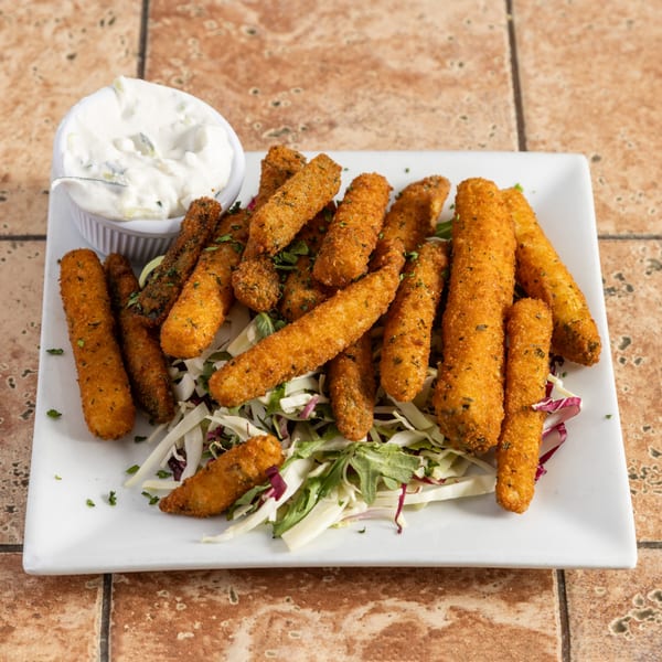 A white rectangular plate filled with golden-brown fried mozzarella sticks, a side of tzatziki, and a bed of lettuce.